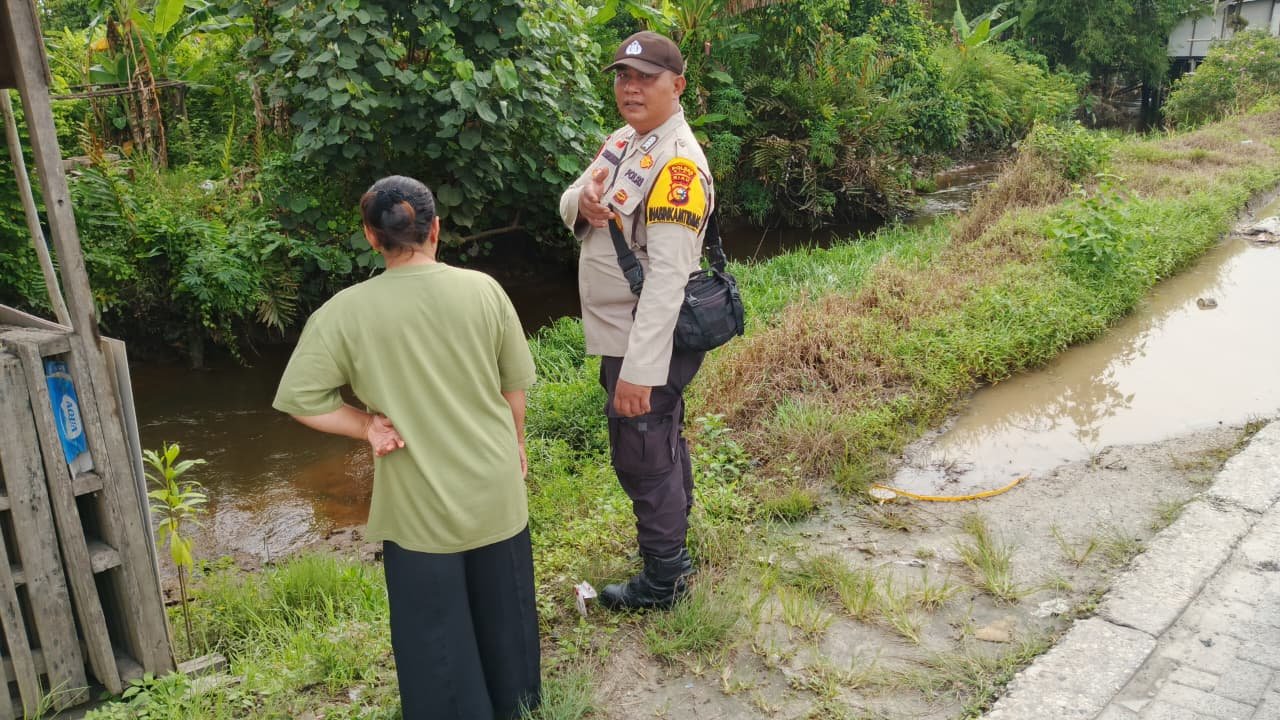 Siaga Musim Hujan, Bhabinkamtibmas Pinang Sebatang Timur Cek Debit Air Sungai Siak
